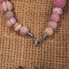 Necklace made from embroidered wool felt beads in shades of soft pink and beige
